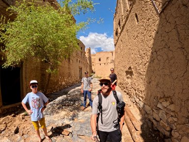 Familie beim Spaziergang durch das Dorf Al Hamra im Oman – Oman Reise mit Kindern