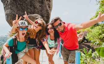 Jugendliche halten fröhlich ein Selfie vor der Dschungellandschaft – Thailand Familienreise