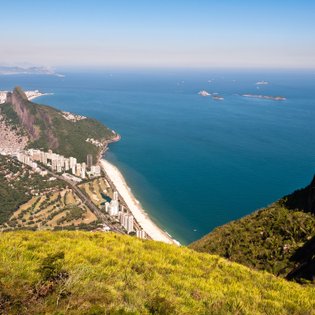 Ein atemberaubender Blick auf die Küste von Rio de Janeiro, mit Stränden, Berglandschaften und dem blauen Ozean im Hintergrund.