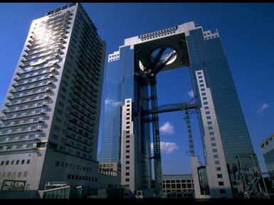 Die beeindruckende Umeda Sky Building in Osaka erhebt sich majestätisch gegen den blauen Himmel, umgeben von modernen Gebäuden.