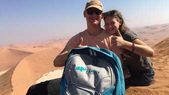 Ein Vater sitzt mit seiner Tochter in der Wüste auf einer Düne - Namibia Urlaub mit Kindern
