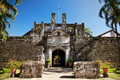 Die beeindruckende Fassade von Fort San Pedro in Cebu City, umgeben von üppigem Grün und strahlend blauem Himmel.