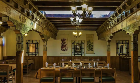 Ein elegantes Restaurant mit Holzbalken und kunstvollen Verzierungen, das eine einladende Atmosphäre ausstrahlt.