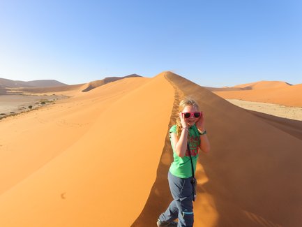 Ein Kind läuft eine Düne hinauf - Namibia Urlaub mit Kindern