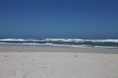 Weitläufiger Sandstrand am Grotto Beach in Hermanus mit Blick auf das Meer – Garden Route Reise mit Kindern