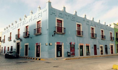 Das Hotel Castelmar ist ein blaues Gebäude mit roten Fensterläden und einem charmanten, historischen Stil.