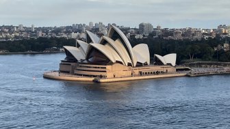 Das ikonische Opernhaus von Sydney erhebt sich majestätisch über das Wasser, umgeben von der Skyline der Stadt.