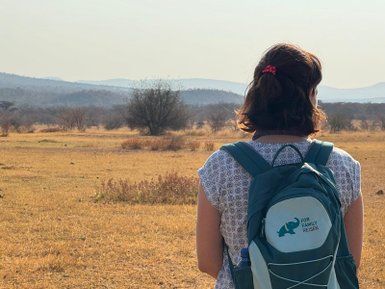 Eine Frau mit FFR-Rucksack schaut über die weite Savanne im Entabeni Game Reserve – Südafrika Reise mit Kindern