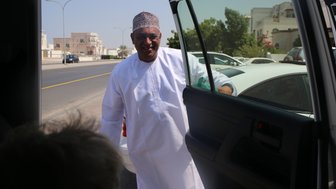 Einheimischer öffnet die Autotür im Oman – Oman mit Kindern