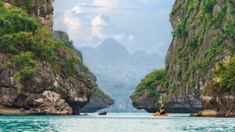 Personen paddeln mit Kajaks durch die Halong-Bucht – Vietnam mit Kindern
