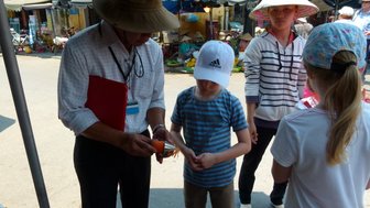 Gruppe von Reisenden erkundet Hoi An mit einem Guide – Vietnam Familienreise