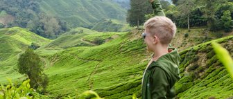 Kind genießt den weiten Ausblick auf die grüne Hügellandschaft der Cameron Highlands – Malaysia & Borneo Familienreise