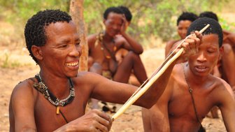 Ein San Mann baut einen Bogen - Namibia Urlaub mit Kindern