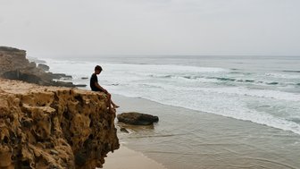 Kind genießt die Aussicht von einem Felsen auf die Agadir-Küste in Marokko – Familienurlaub in Marokko