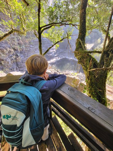 Ein Kind steht am Aussichtspunkt und blickt über die weite Landschaft der Panorama Route – Südafrika Reise mit Kindern