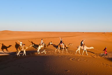 Familie erlebt eine Kameltour als Karawane durch die weiten Dünen der Sahara – Marokko mit Kindern