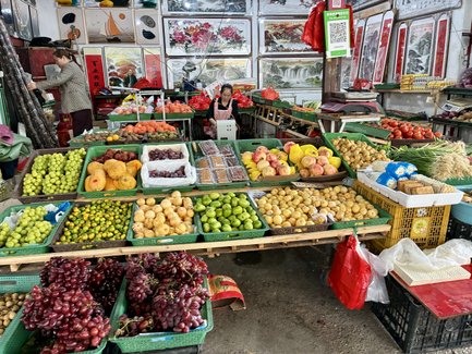 Ein lebhafter Bauernmarkt mit bunten Obst- und Gemüsekörben, die eine Vielzahl frischer Produkte präsentieren.