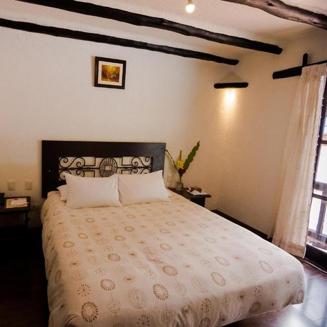 Ein gemütliches Schlafzimmer mit einem großen Bett, weißen Kissen und einem Fenster, das Tageslicht hereinlässt.