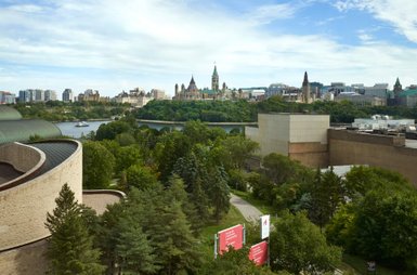 Ein Blick auf die malerische Skyline von Ottawa, umgeben von üppigem Grün und dem ruhigen Wasser des Ottawa-Flusses.