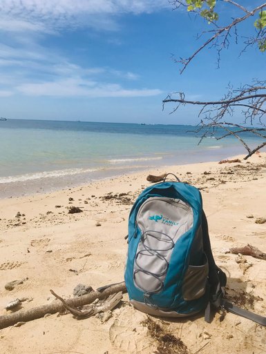 FFR Rucksack liegt im Schatten am weißen Sandstrand von Cahuita – Costa Rica Familienreise
