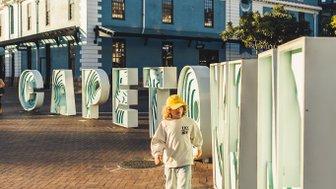 Kind steht vor dem „Cape Town“-Schild – Südafrika Familienreise