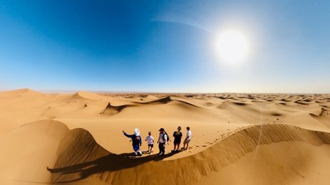 Familie steht in Sanddünen der Sahara - Marokko mit Kindern