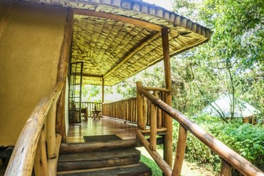 Eine einladende Veranda mit Holzgeländer und einem Blick auf die üppige grüne Umgebung, ideal für Entspannung.