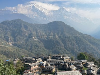 Das malerische Dorf Ghandruk liegt eingebettet zwischen majestätischen, schneebedeckten Bergen und üppigen Hügeln.
