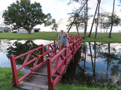 Holzbrücke führt über einen Fluss im tropischen Garten des Nexus Resorts – Malaysia & Borneo Reise mit Kindern