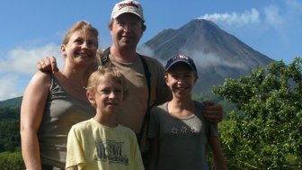 Familie steht vor dem Vulkan Arenal in der üppigen Landschaft von Costa Rica – Costa Rica Familienreise
