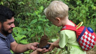 Kleinkind und Guide beim Baumpflanzen in La Tigra – Costa Rica Familienreise