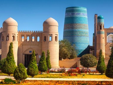 Die beeindruckende Architektur der historischen Stadt mit leuchtend blauen Türmen und grünen Bäumen im Vordergrund.