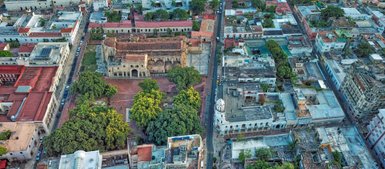 Eine Luftaufnahme von Santo Domingo zeigt die Plaza Colón mit historischen Gebäuden und üppigem Grün in der Umgebung.