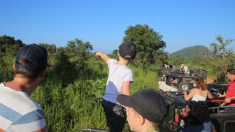Auf Safari im Minneriya Nationalpark zeigt ein Kind begeistert auf Landschaft – Sri Lanka Reise mit Kindern