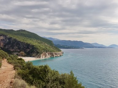 Eine malerische Küstenlandschaft mit sanften Hügeln und klarem Wasser, ideal für einen entspannten Strandtag.