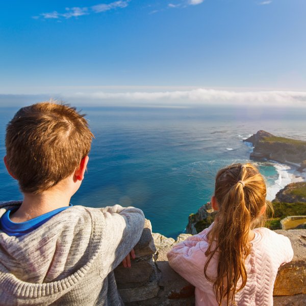 Kinder stehen am Aussichtspunkt des Kaps der Guten Hoffnung und blicken auf das weite Meer – Garden Route Familienreise