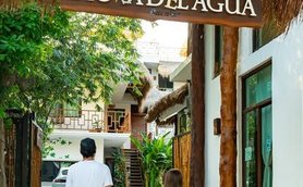 Ein Paar steht vor dem Eingang des Hotels Diosa del Agua, umgeben von üppigem Grün und einem einladenden Ambiente.