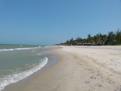 Ein ruhiger Strand mit feinem Sand, sanften Wellen und einer klaren blauen Himmel, ideal für einen entspannten Tag am Meer.