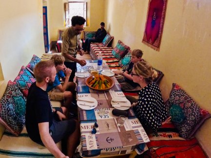 Familie genießt traditionelles Essen gemeinsam mit Einheimischen in Aït Ben Haddou – Marokko Familienreise