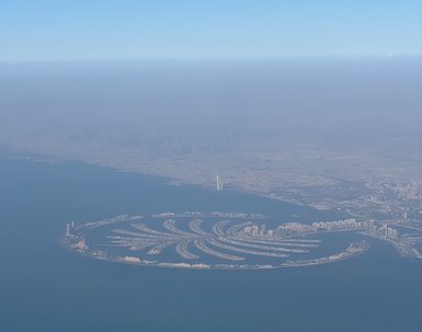 Ein Blick auf die Palm Jumeirah, eine künstliche Insel in Form einer Palme, umgeben von klarem Wasser und einem blauen Himmel.