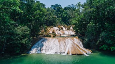 Kinder erfrischen sich an einem Wasserfall im Dschungel von Lacanjá – Mexiko mit Kindern