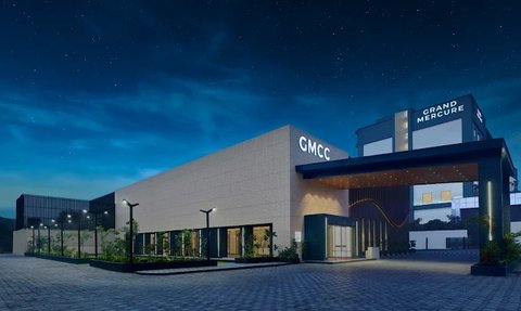 Die moderne Fassade des Grand Mercure Hotels strahlt Eleganz aus, umgeben von sanften Landschaftselementen und einem klaren Nachthimmel.