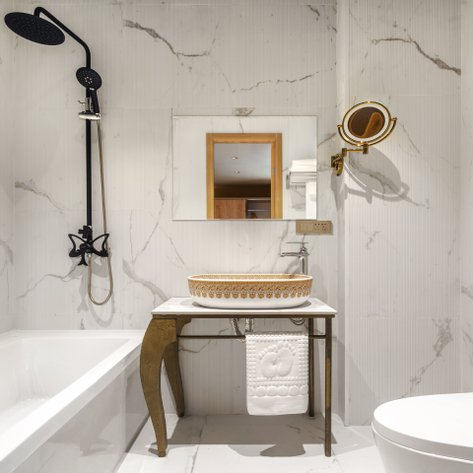 Ein modernes Badezimmer mit eleganten Marmorwänden, einer freistehenden Badewanne und einem stilvollen Waschbecken.