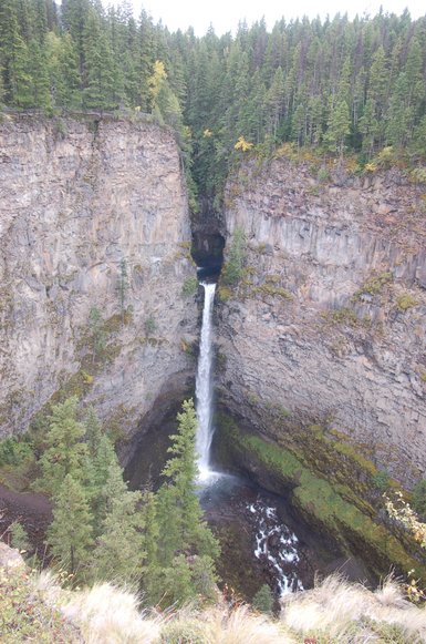 Imposanter Wasserfall stürzt in eine tiefgrüne Schlucht, umgeben von steilen, moosbewachsenen Felsen und dichten Wäldern.