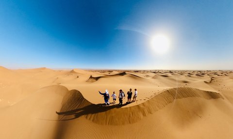 Familie steht in Sanddünen der Sahara - Marokko mit Kindern