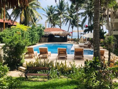 Ein einladender Poolbereich umgeben von Palmen und üppigem Grün, ideal für entspannende Tage in Playa del Carmen.