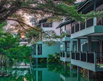 Ein ruhiges Resort am Wasser mit modernen Zimmern, umgeben von üppigem Grün und sanften Lichtverhältnissen.
