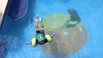 Kleinkind planscht fröhlich am Pool der Mawamba Lodge im Tortuguero Nationalpark – Costa Rica Familienreise