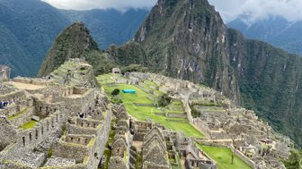 Die beeindruckenden Ruinen von Machu Picchu liegen majestätisch in den Anden, umgeben von grünen Hügeln und dramatischen Wolken.