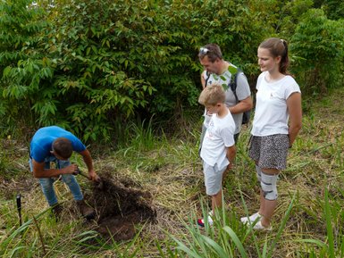Guide unterstützt Familie beim Baum Pflanzen – Costa Rica mit Kindern
